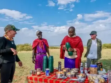 Maasai guides hosting a traditional outdoor lunch for travelers